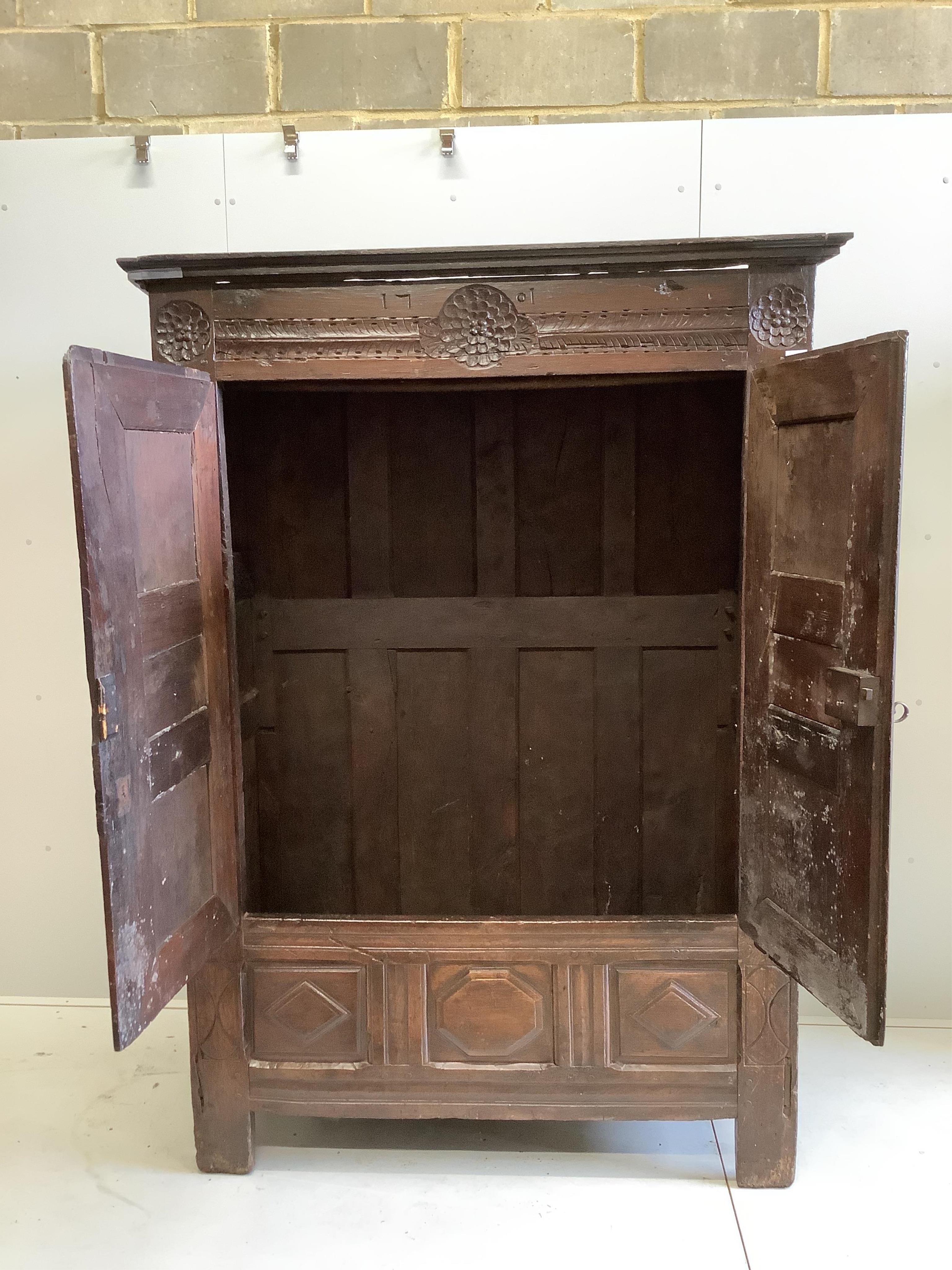 An early 18th century continental panelled oak cupboard bearing date 1701, width 130cm, height 193cm. Condition - fair, cornice detached, lacks inner shelves